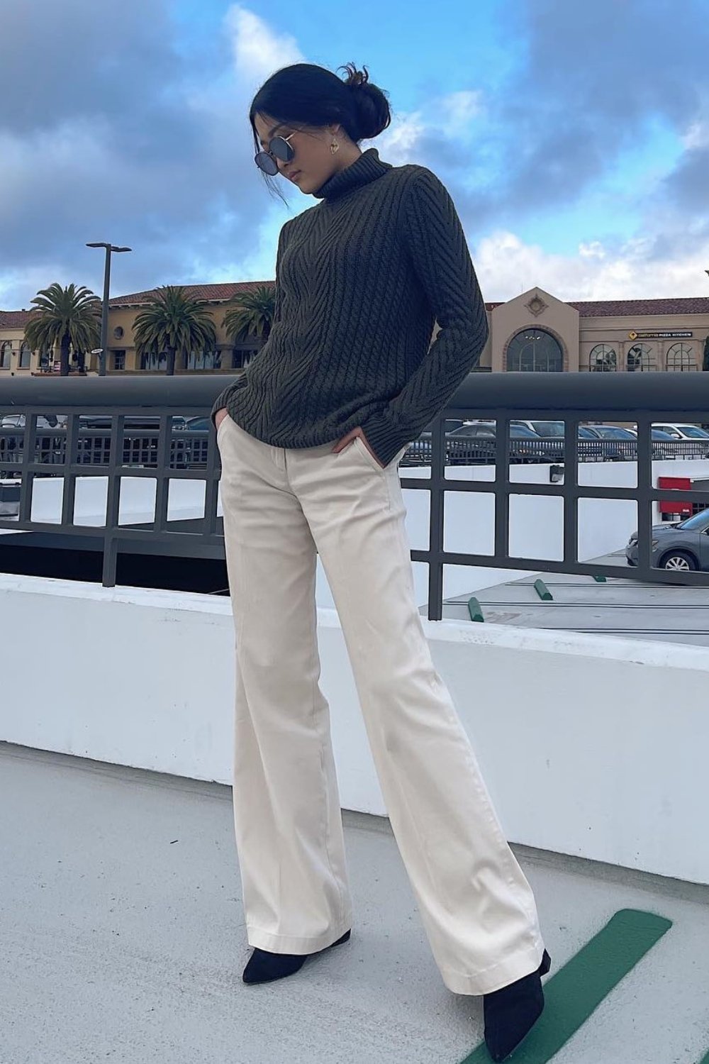 Dark turtleneck sweater with beige trousers