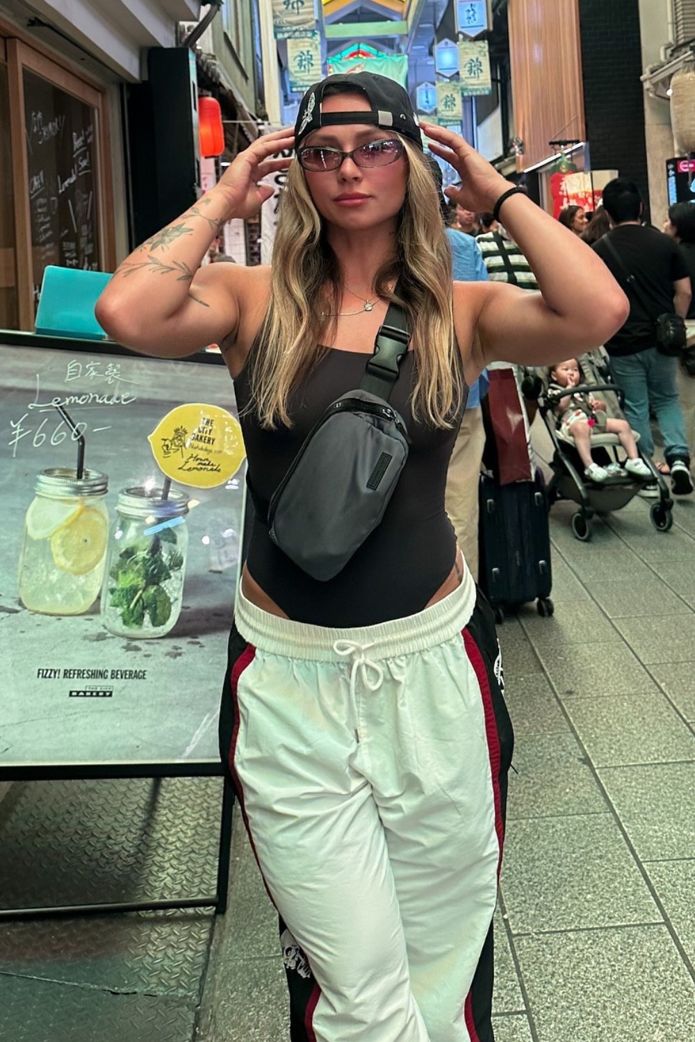 White Track Pants, Black Bodysuit, and Baseball Cap