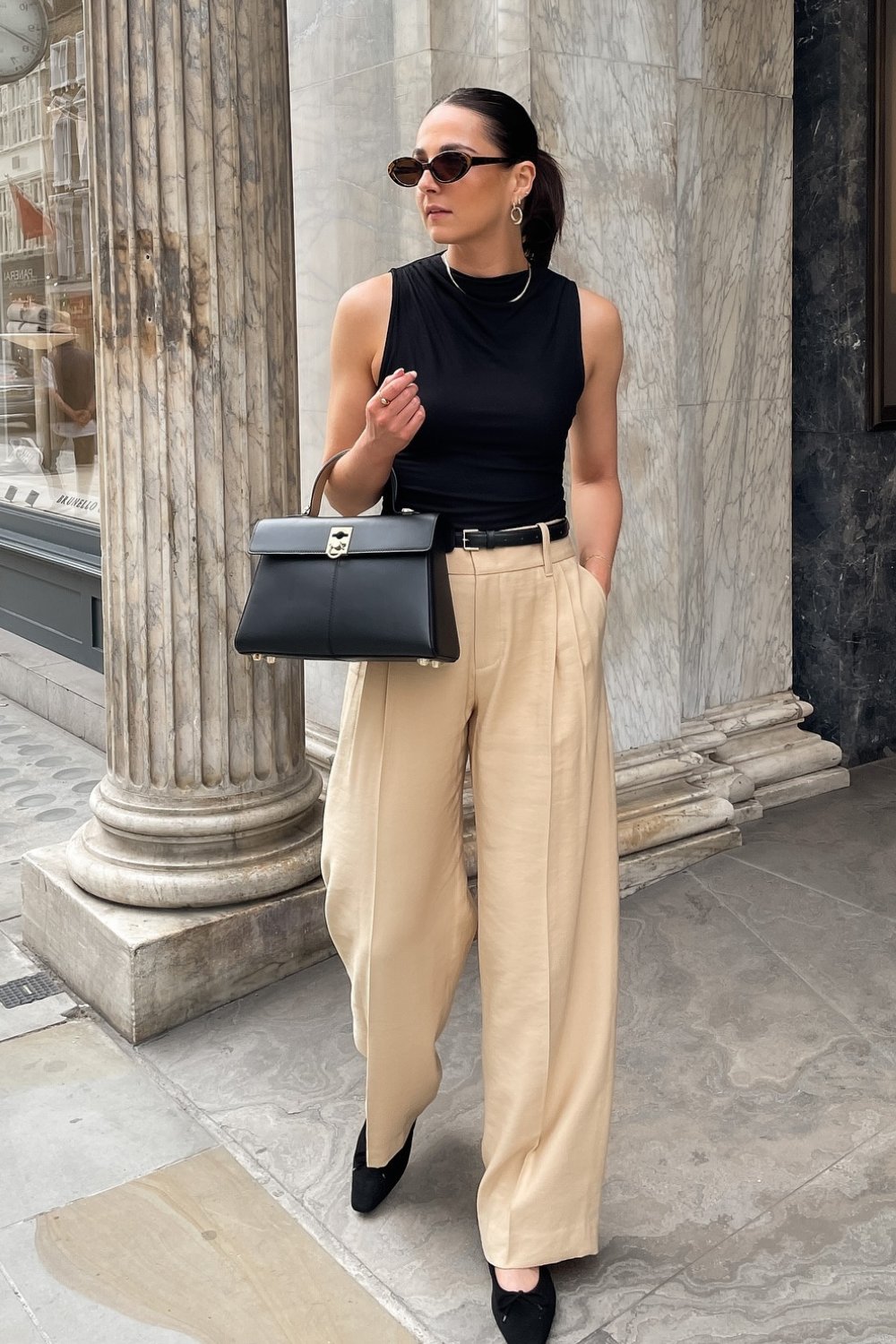 Black Sleeveless Turtleneck Top, Beige Trousers, and Black Belt