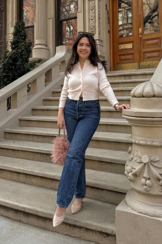 White button-up cardigan, blue straight-leg jeans, and nude kitten heels