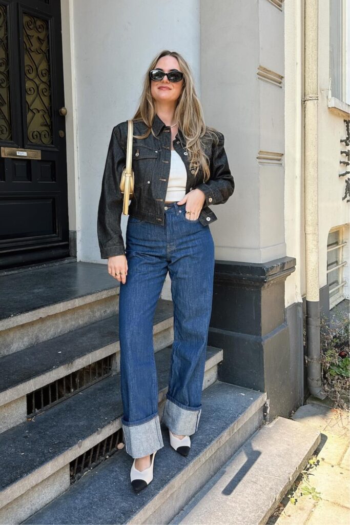 Dark denim cropped jacket, white tank top, blue wide-leg jeans, and kitten heels